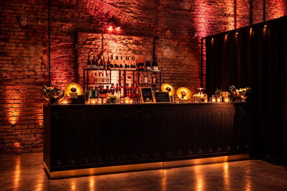 Mobilny bar koktajlowy LateNightCocktailClub w ceglanej hali, oświetlony ciepłym światłem